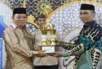 [Camat Tilongkabila, Imran Gaib menerima penghargaan sebagai Juara 1 Umum pada pelaksanaan Seleksi Tilawatil Quran dan Hadist (STQH) Tingkat Kabupaten Bone Bolango yang diserahkan Wakil Bupati Bone Bolango Risman Tolingguhu, Sabtu malam (24/5). (Foto : Yudi/Prokopim)]. 