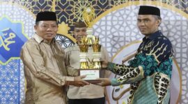 [Camat Tilongkabila, Imran Gaib menerima penghargaan sebagai Juara 1 Umum pada pelaksanaan Seleksi Tilawatil Quran dan Hadist (STQH) Tingkat Kabupaten Bone Bolango yang diserahkan Wakil Bupati Bone Bolango Risman Tolingguhu, Sabtu malam (24/5). (Foto : Yudi/Prokopim)]. 