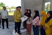 Camat Tilongkabila Kabupaten Bone Bolango, Imran Gaib, saat menyerahkan secara simbolis Cadangan Beras Pemerintah (CBP) untuk Bulan Juni-Juli 2025 kepada Keluarga Penerima Manfaat (KPM) di Desa Tunggulo Kecamatan Tilongkabila, Kamis (24/7).